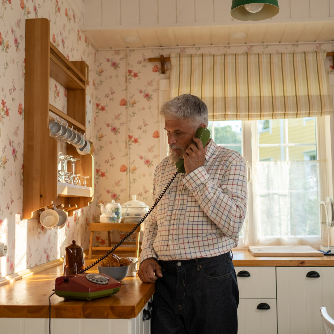 A man answers his landline phone